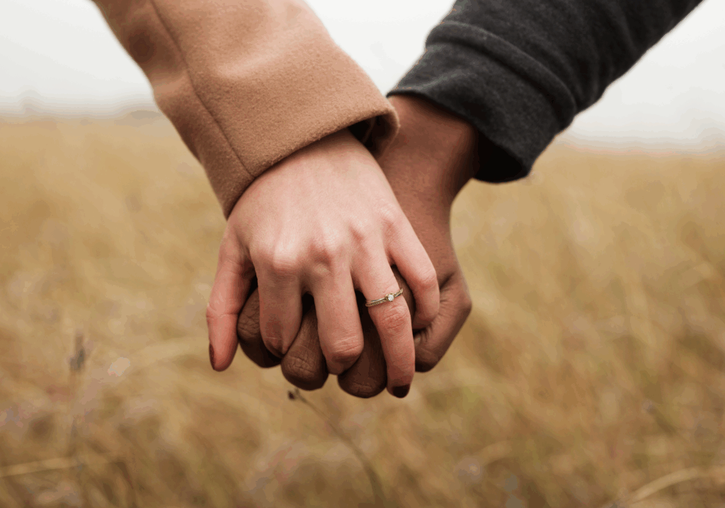 Close-up of a man placing a ring on a woman’s finger, symbolizing love and marriage for Kind Wealth’s article on pre-nups.